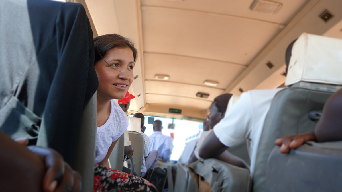 Lissette Mateus Roa discusses the power of forgiveness in Uganda with participants en route to a site visit.